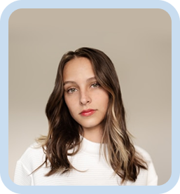 Woman with shoulder-length brown hair wearing a white top, looking forward against a neutral beige background