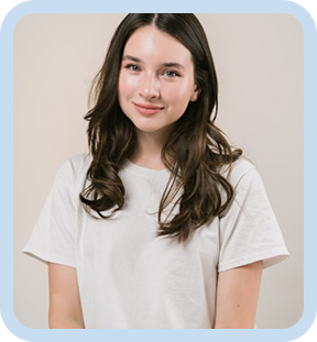 Smiling woman with long brown hair wearing a white t-shirt standing against a neutral background